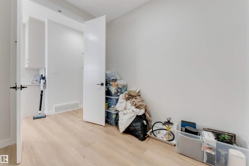Light wood-finish flooring extending from the foreground into the background - 7007 169 Avenue Nw, Edmonton, AB - Indoor Photo Showing Other Room