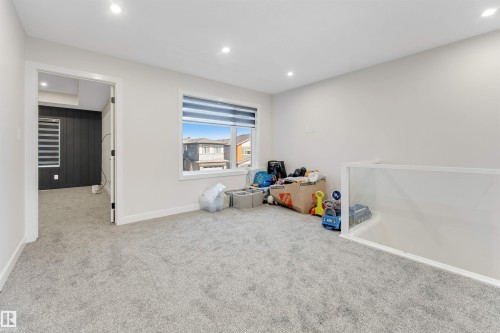 Carpeted loft space with a window, recessed lighting, and a glass railing - 7007 169 Avenue Nw, Edmonton, AB - Indoor Photo Showing Other Room