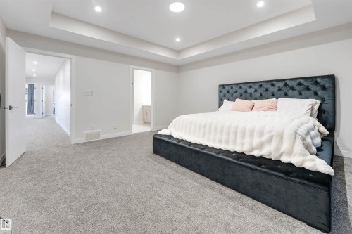 Spacious room featuring light gray carpeting, recessed lighting, and a tray ceiling - 7007 169 Avenue Nw, Edmonton, AB - Indoor Photo Showing Bedroom