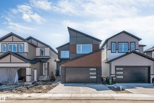 Modern architectural home featuring an angled roofline, dark grey siding, and horizontal wood-finish accents - 7007 169 Avenue Nw, Edmonton, AB - Outdoor With Facade