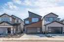 Modern architectural home featuring an angled roofline, dark grey siding, and horizontal wood-finish accents - 7007 169 Avenue Nw, Edmonton, AB  - Outdoor With Facade 