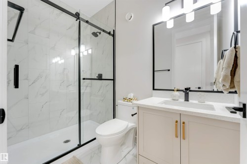 Bathroom featuring a matte black framed glass shower enclosure and white marble-patterned tile - 7007 169 Avenue Nw, Edmonton, AB - Indoor Photo Showing Bathroom