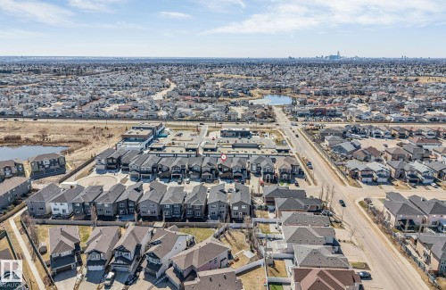 Aerial perspective showcasing a residential development featuring rows of townhomes and detached properties - 7007 169 Avenue Nw, Edmonton, AB - Outdoor With View