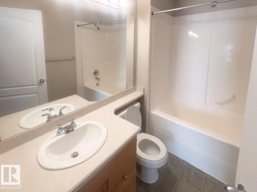 Bathroom vanity with an integrated sink, polished chrome faucet, and expansive mirror - 6120 7331 South Terwillegar Drive Nw, Edmonton, AB - Indoor Photo Showing Bathroom