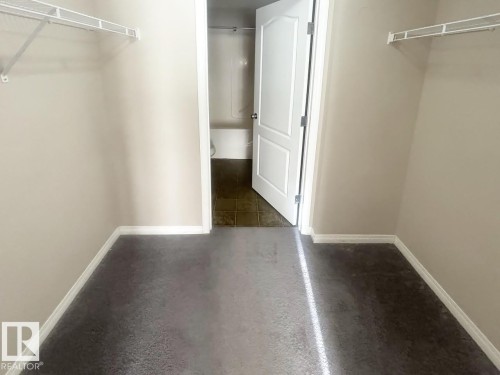 Walk-in closet featuring carpet flooring, neutral wall paint, white trim, and wire shelving - 6120 7331 South Terwillegar Drive Nw, Edmonton, AB - Indoor Photo Showing Other Room