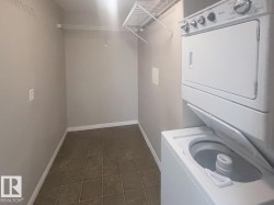 Dedicated laundry area featuring a stacked washer and dryer unit - 