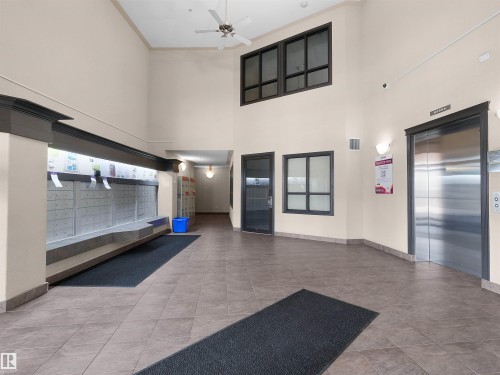 Two-story foyer featuring tiled flooring and a stainless steel elevator - 7123 7327 South Terwillegar Drive, Edmonton, AB - Indoor Photo Showing Other Room