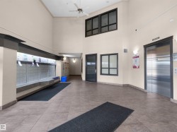 Two-story foyer featuring tiled flooring and a stainless steel elevator - 
