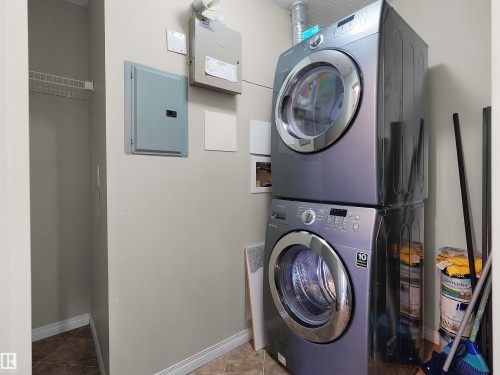 Dedicated laundry area featuring stacked appliances - 7123 7327 South Terwillegar Drive, Edmonton, AB - Indoor Photo Showing Laundry Room