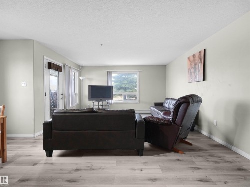 Spacious living area featuring light-toned walls, wood-finish flooring, and white trim - 7123 7327 South Terwillegar Drive, Edmonton, AB - Indoor