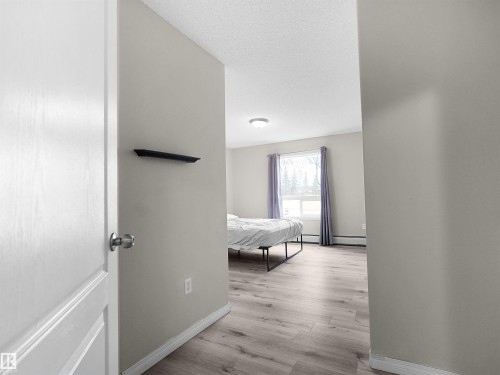 Spacious room featuring wood-finish flooring, a large window with natural light, neutral wall colors, and white trim - 7123 7327 South Terwillegar Drive, Edmonton, AB - Indoor Photo Showing Other Room