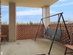 Covered patio featuring a concrete floor, stone accent pillar, and lattice privacy screening - 