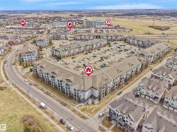 Expansive aerial view of a multi-unit residential complex featuring multiple buildings with private balconies and a large central parking area - 