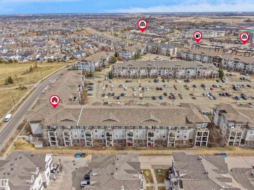 Multi-story residential building featuring balconies and a large parking area - 7123 7327 South Terwillegar Drive, Edmonton, AB - Outdoor With View