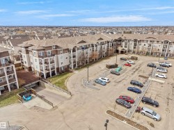 Multi-story apartment building with a composite shingle roof, private balconies, and an exterior of siding and stone accents - 