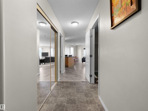 Hallway featuring tile flooring, mirrored closet doors, and overhead lighting - 7123 7327 South Terwillegar Drive, Edmonton, AB - Indoor Photo Showing Other Room