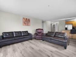 Spacious interior featuring light wood-finish flooring, neutral wall paint, and a textured ceiling - 