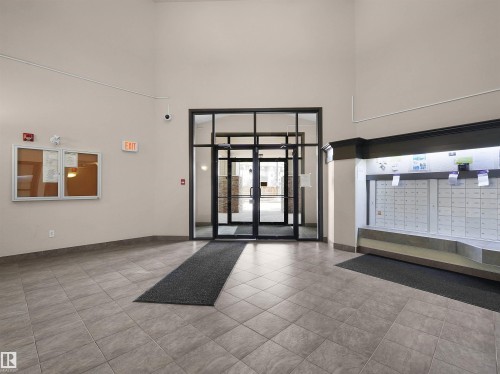 Building lobby with a tile floor, glass entry doors, and a mailroom bank - 7123 7327 South Terwillegar Drive, Edmonton, AB - Indoor Photo Showing Other Room