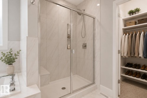 Walk-in shower with clear glass enclosure and built-in bench. Virtually Staged. - 635 42 Street, Edmonton, AB - Indoor Photo Showing Bathroom