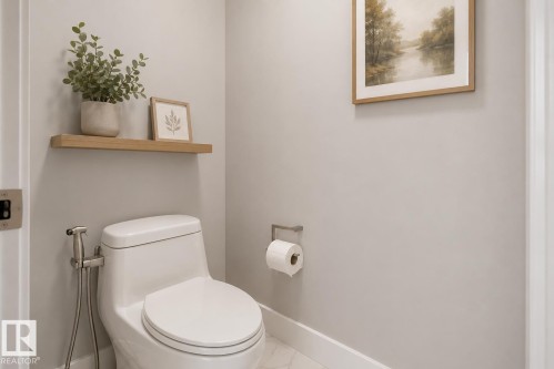 Contemporary toilet with a bidet sprayer, a floating wood-finish shelf, and light gray wall paint. Virtually Staged. - 635 42 Street, Edmonton, AB - Indoor Photo Showing Bathroom