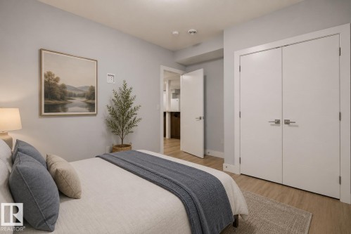 Light wood-finish flooring complements the light gray wall paint. Virtually Staged. - 635 42 Street, Edmonton, AB - Indoor Photo Showing Bedroom