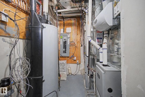 Utility area featuring a water heater, electrical panel, and HVAC system with exposed ductwork and piping - 635 42 Street, Edmonton, AB - Indoor Photo Showing Basement