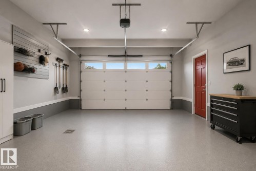 Spacious two-car garage featuring an epoxy-coated concrete floor, an overhead door with transom windows, and recessed ceiling lighting. Virtually Staged. - 635 42 Street, Edmonton, AB - Indoor Photo Showing Garage