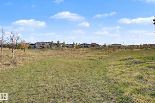 Expansive grassy terrain with rolling hills and distant residential structures. Nearby Park - 635 42 Street, Edmonton, AB - Outdoor With View