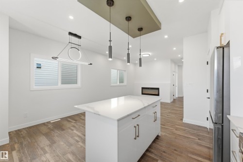 Contemporary kitchen island with a quartz countertop and integrated storage - 12447 47 Street, Edmonton, AB - Indoor Photo Showing Other Room
