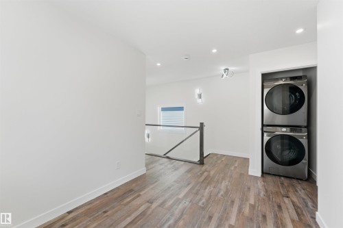 Convenient laundry area featuring a stacked washer and dryer within a dedicated alcove - 12447 47 Street, Edmonton, AB - Indoor Photo Showing Laundry Room