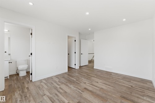 Expansive room featuring wood-finish flooring and recessed lighting - 12447 47 Street, Edmonton, AB - Indoor Photo Showing Other Room