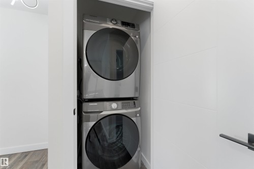 Dedicated laundry closet featuring a stacked washer and dryer unit - 12447 47 Street, Edmonton, AB - Indoor Photo Showing Laundry Room