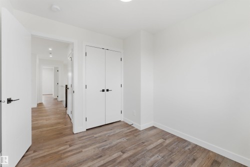 Room featuring wood-finish flooring and bright white walls - 12447 47 Street, Edmonton, AB - Indoor Photo Showing Other Room