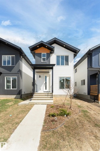 Modern architectural facade featuring white horizontal siding and dark vertical siding accents - 12447 47 Street, Edmonton, AB - Outdoor