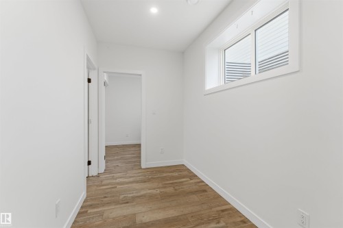 Bright room featuring wood-finish flooring, recessed lighting, white walls, and a casement window with white trim - 12447 47 Street, Edmonton, AB - Indoor Photo Showing Other Room