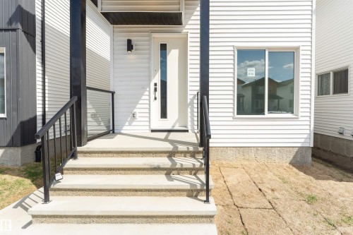Modern white siding exterior with contrasting black trim - 12447 47 Street, Edmonton, AB - Outdoor With Exterior