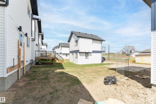 Newly constructed residential property featuring white siding with dark trim accents - 12447 47 Street, Edmonton, AB - Outdoor With Exterior