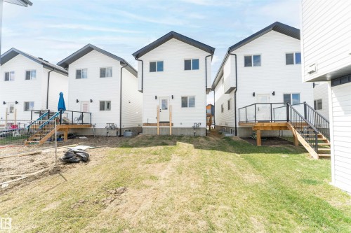Three contemporary residences with white siding and dark gabled roofs, each featuring a private deck - 12447 47 Street, Edmonton, AB - Outdoor