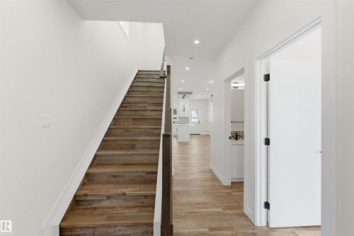 Hardwood staircase with modern wood and metal handrail, leading to an upper level - 12447 47 Street, Edmonton, AB - Indoor Photo Showing Other Room