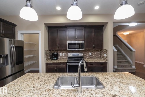 Kitchen island featuring a double basin stainless steel sink with a chrome faucet - 151 Caledonia Drive, Leduc, AB - Indoor Photo Showing Kitchen With Double Sink With Upgraded Kitchen