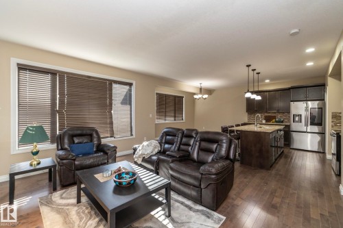 Open-concept living area featuring wood-finish flooring, recessed lighting, and large windows with blinds - 151 Caledonia Drive, Leduc, AB - Indoor Photo Showing Living Room