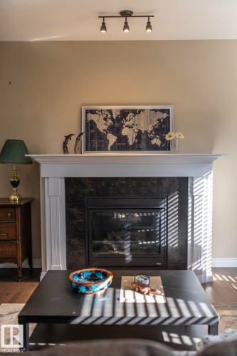 White-finished fireplace mantel with dark tile surround and an integrated firebox - 151 Caledonia Drive, Leduc, AB - Indoor With Fireplace
