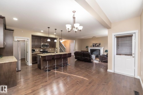 Spacious open-concept living area featuring wood-finish flooring - 151 Caledonia Drive, Leduc, AB - Indoor