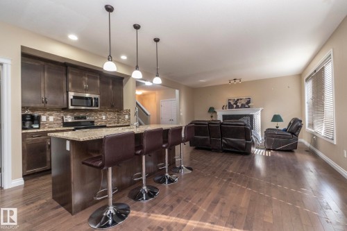 Open-concept living area featuring wood-finish flooring - 151 Caledonia Drive, Leduc, AB - Indoor Photo Showing Kitchen With Upgraded Kitchen