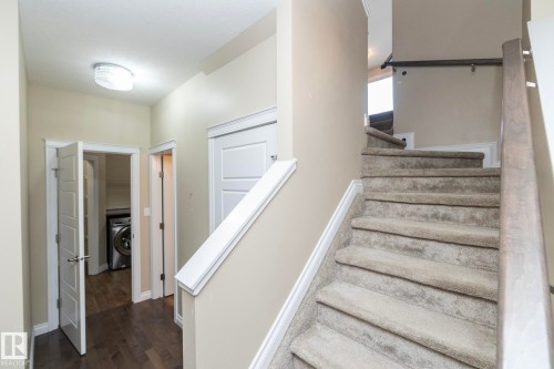 Carpeted staircase with wooden handrail, leading to an upper level - 151 Caledonia Drive, Leduc, AB - Indoor Photo Showing Other Room