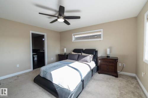 Bedroom featuring neutral wall paint, light-toned carpeting, and a ceiling fan with integrated lighting - 151 Caledonia Drive, Leduc, AB - Indoor Photo Showing Bedroom