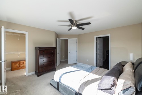 Carpeted bedroom with neutral wall tones and a ceiling fan with integrated lighting - 151 Caledonia Drive, Leduc, AB - Indoor Photo Showing Bedroom
