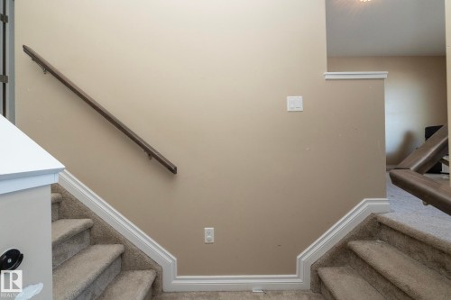 Carpeted split-level staircase with white trim and neutral wall paint - 151 Caledonia Drive, Leduc, AB - Indoor Photo Showing Other Room