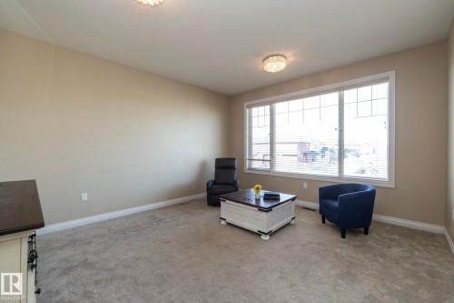Spacious room featuring neutral paint, light-colored carpeting, and white baseboards - 151 Caledonia Drive, Leduc, AB - Indoor