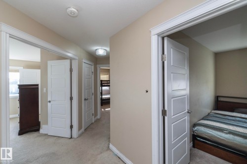 Hallway featuring light-toned walls, white trim, and carpet flooring - 151 Caledonia Drive, Leduc, AB - Indoor Photo Showing Bedroom